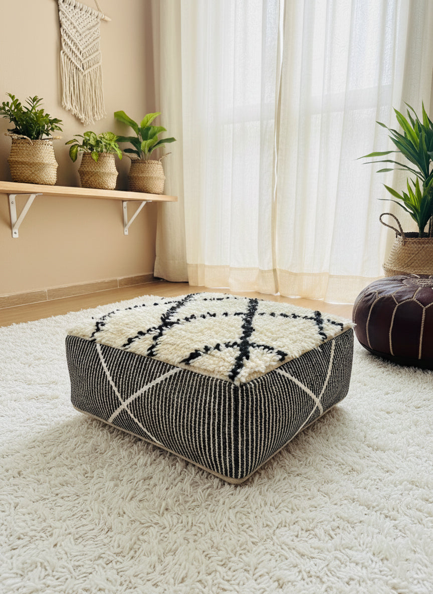 Berber wool pouf placed in a bright bohemian room with plants.