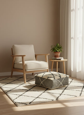 Minimalist reading corner featuring a beige and black Moroccan pouf.