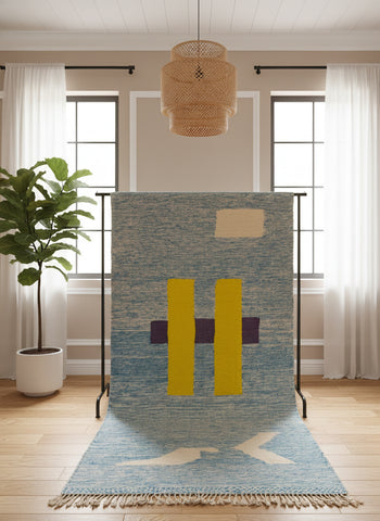 Blue Tafida rug displayed on a stand showing its geometric wool design.