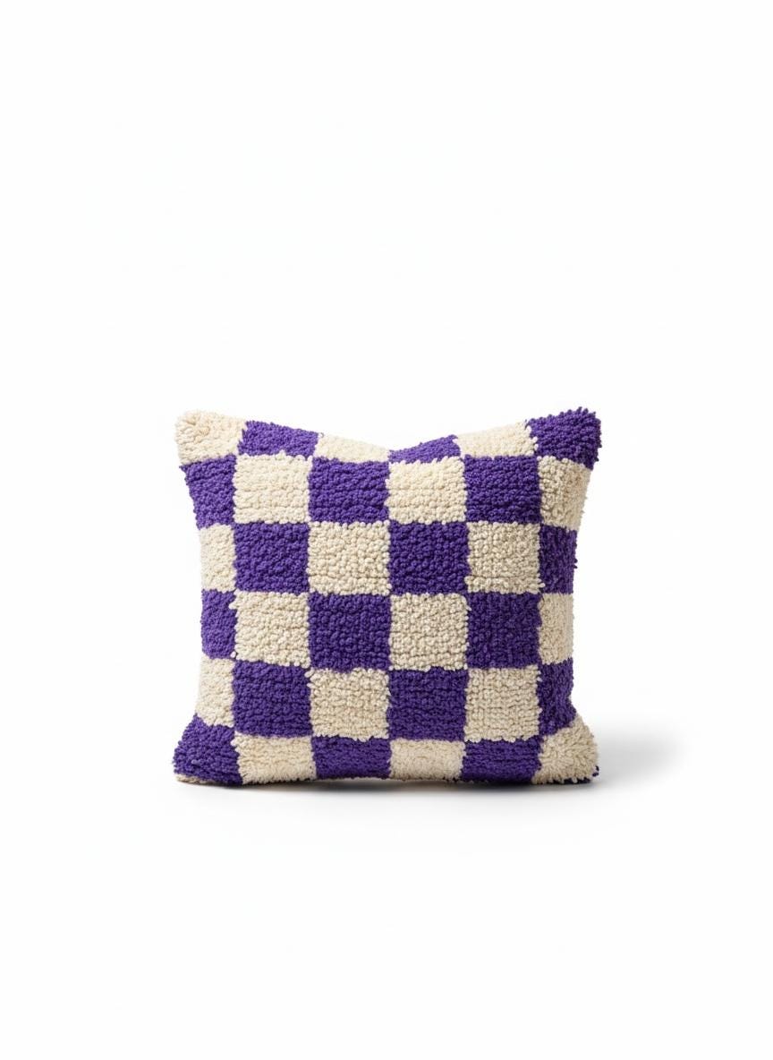 Purple and cream Moroccan checkered wool pillow on neutral background.