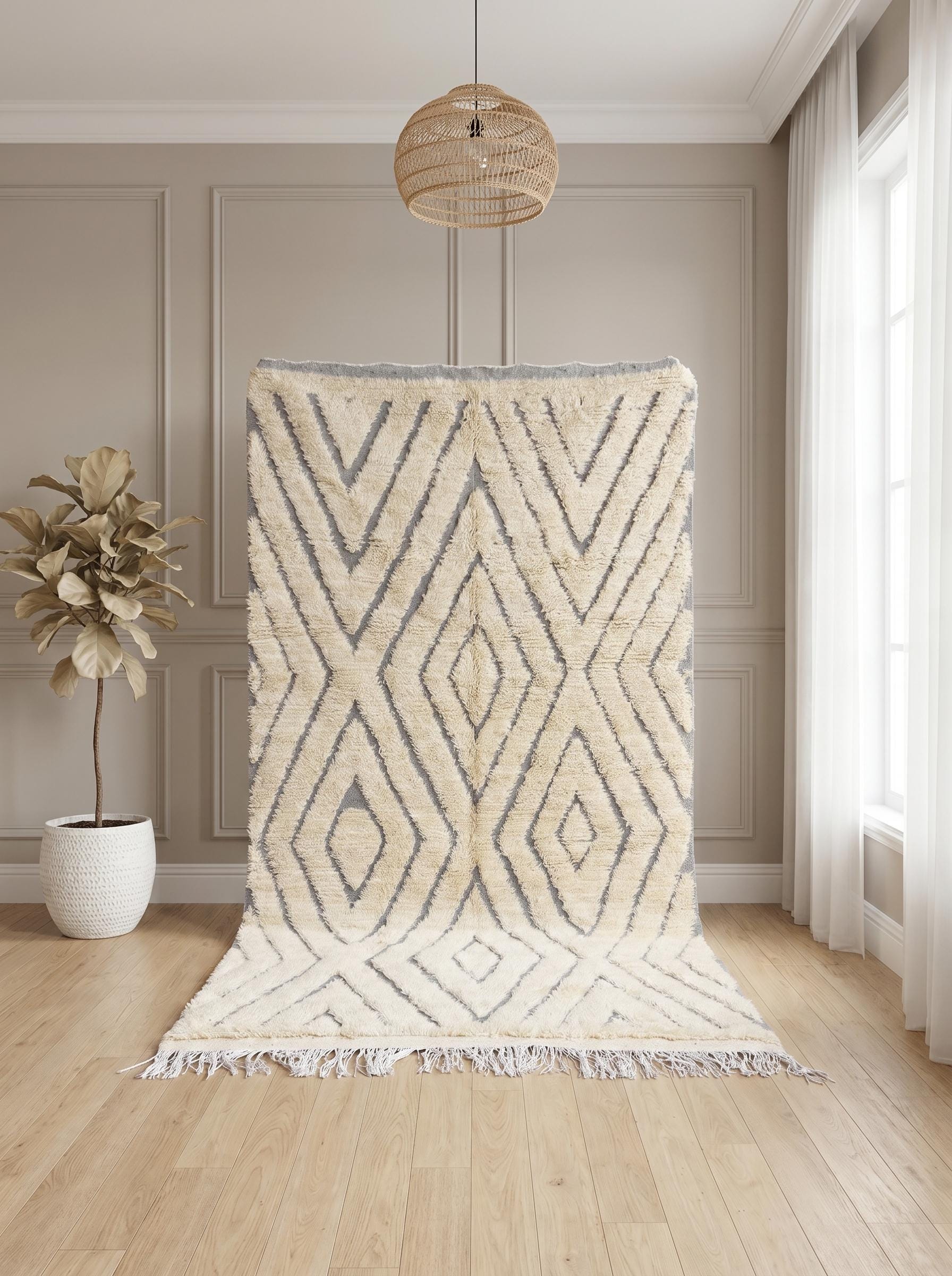 Handwoven Moroccan rug displayed vertically showing textured cream wool and bold grey diamond pattern.