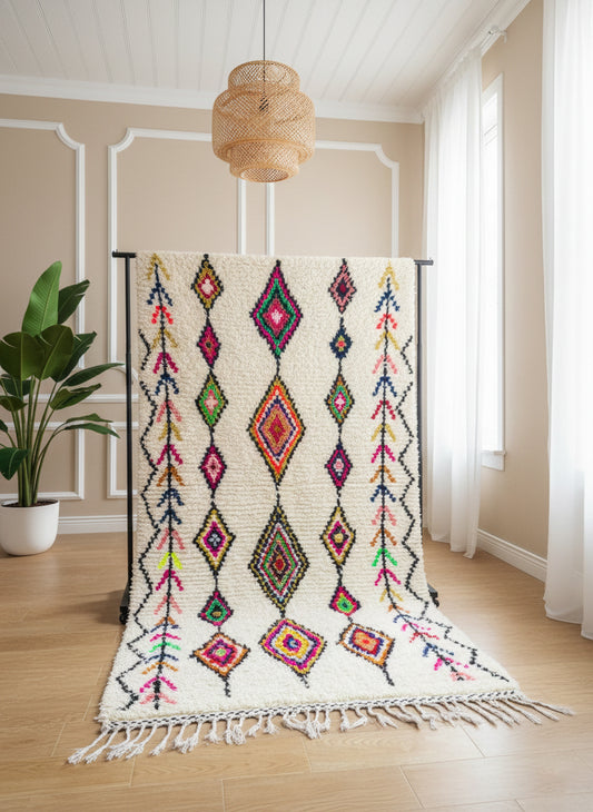 Cream Berber rug with colorful rhombus motifs displayed in a bright room.
