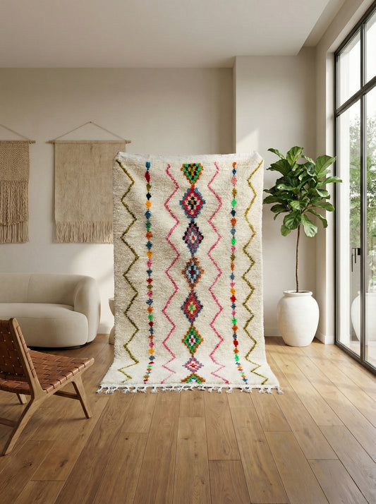 Cream Ismene rug with colorful Berber patterns in a modern room
