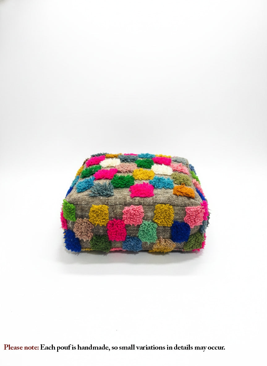 Front view of Berber Ider pouffe with bright wool tufts on a white background.