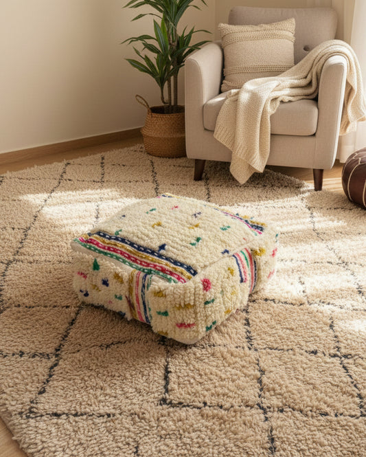 Berber Adnen wool pouf on a textured beige rug