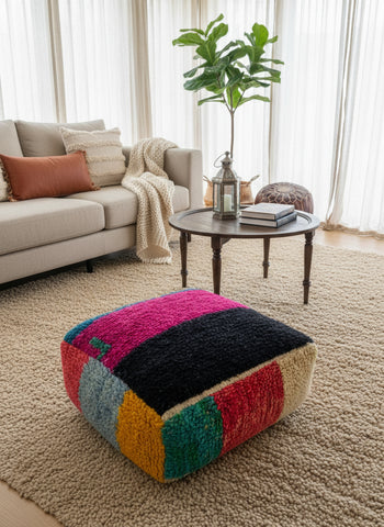 Colorful patchwork ottoman in a living room with a sofa and coffee table.