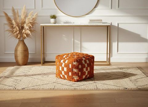 Textured orange wool pouf styled on beige Moroccan rug