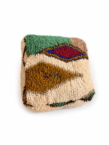 Artisan Moroccan floor pouf handcrafted from wool with vibrant diamond patterns and plush texture.