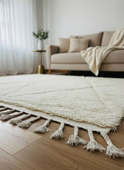 Sifaw beige rug with tassels placed under sofa in bright minimalist interior