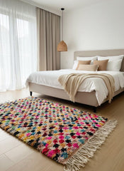 Handmade pink wool rug with multicolor texture in bedroom