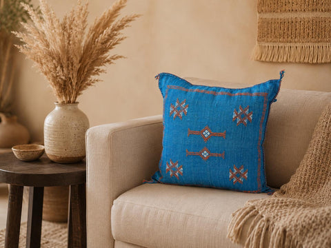 Blue cactus silk cushion cover showcased in a warm bohemian living room setting.