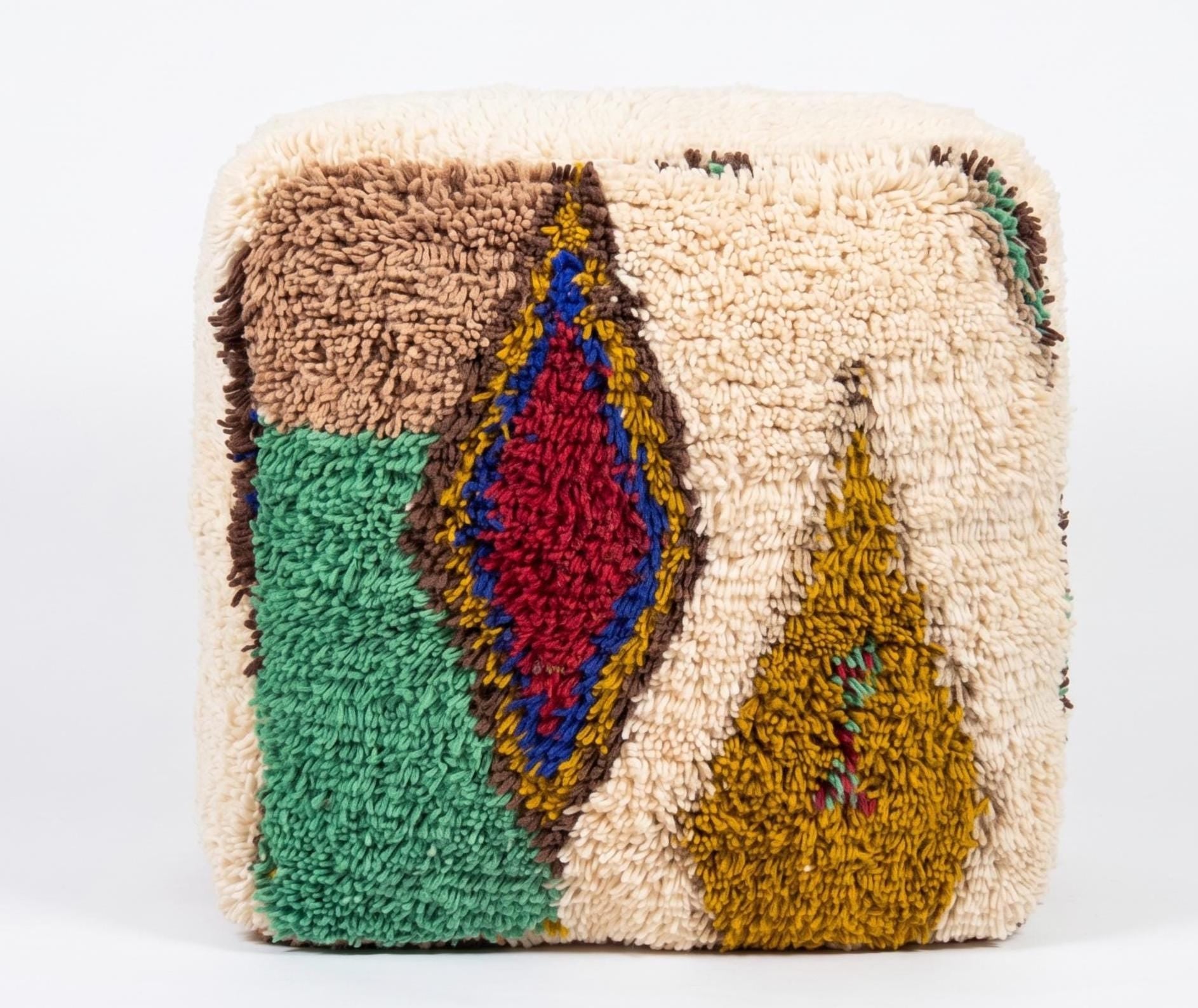 Close-up of a Moroccan Berber pouf showcasing thick wool pile, intricate geometric motifs, and artisan craftsmanship.