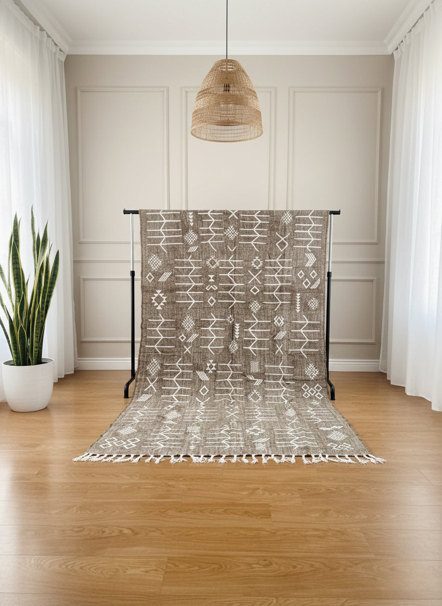 Gray Berber Idya rug displayed on stand with white tribal symbols in a bright room
