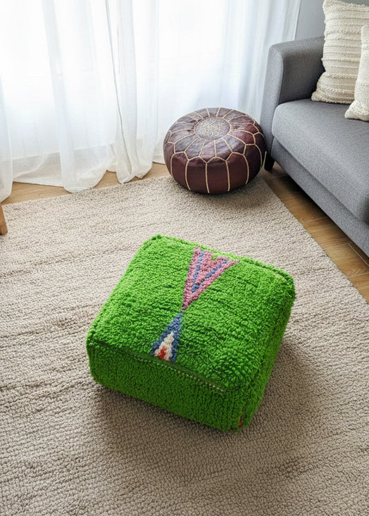 Handmade green Moroccan pouffe styled in a cozy living room.
