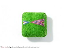 Top view of green Moroccan pouffe with colorful geometric pattern.