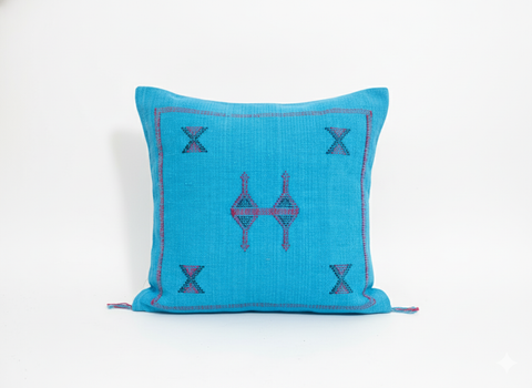 Close-up of turquoise Tasga Berber pillow with traditional embroidery on white background