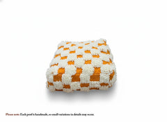Orange and cream checkered Berber Akil pouffe on white background.