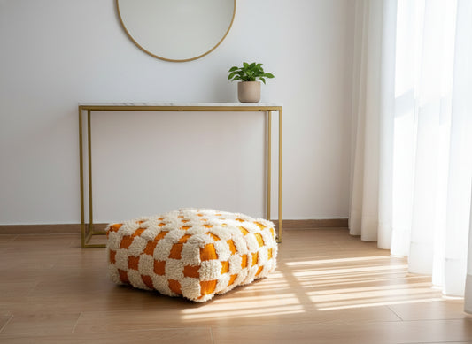 Orange and cream Moroccan pouffe in a bright minimalist room.