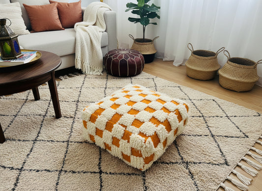 Berber Akil pouffe styled in a cozy living room on a beige rug.