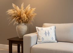 Tilya Berber pillow on beige sofa beside rustic vase with pampas grass