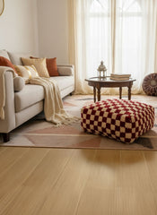 Checker-pattern Berber wool pouf in a warm living room beside a beige sofa