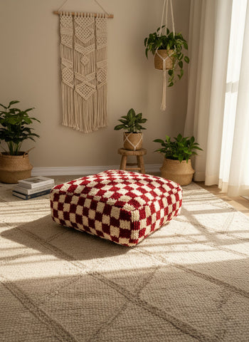 Fuchsia and white Moroccan pouf styled in a cozy boho living room with plants