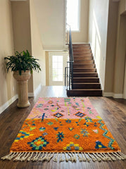 Pink and orange Berber rug in a bright hallway.