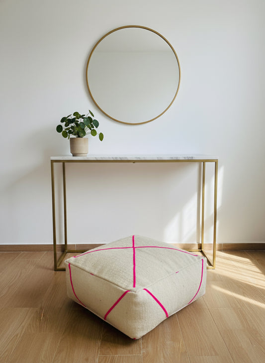 Modern Moroccan pouf under mirror on wooden floor
