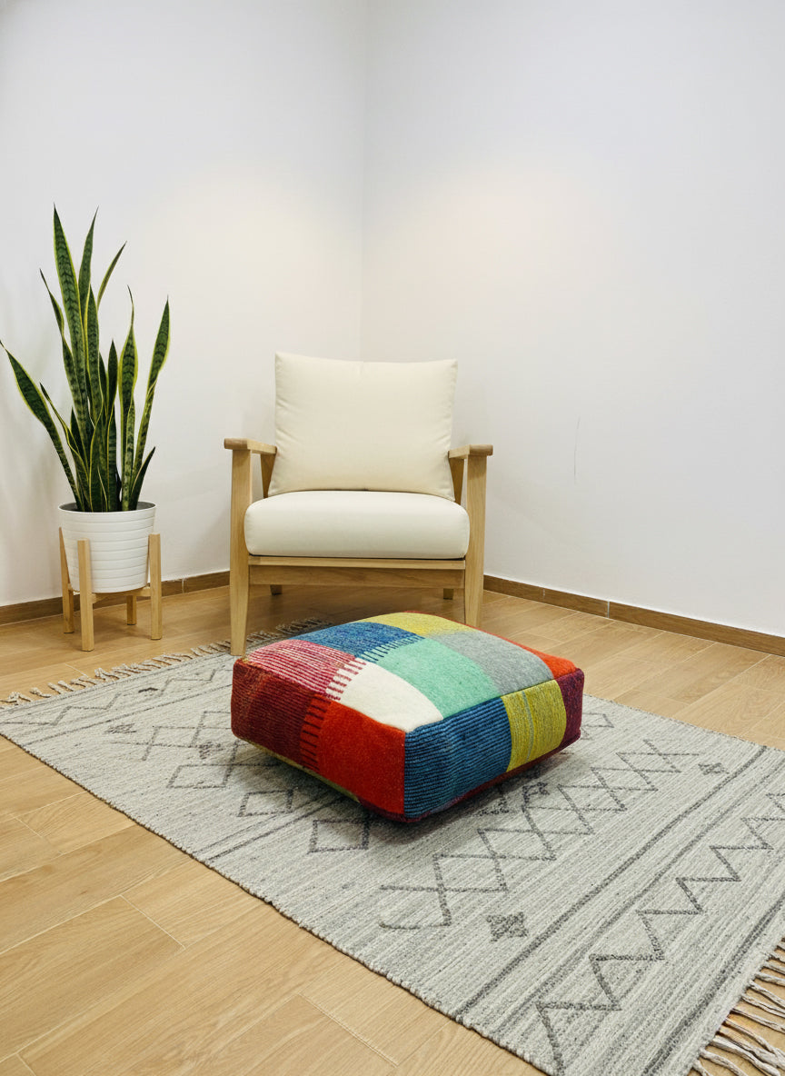 Handmade Berber colorful pouf styled with a modern armchair and indoor plant