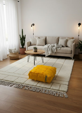 Yellow Berber pouf adding color in a neutral living room with natural decor.