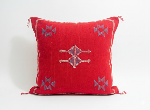 Handmade red Berber cushion with geometric embroidery on white background