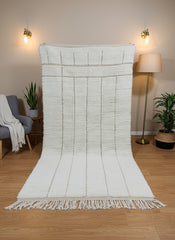 Full view of Tazgart Moroccan rug displayed vertically with tassels and modern décor.