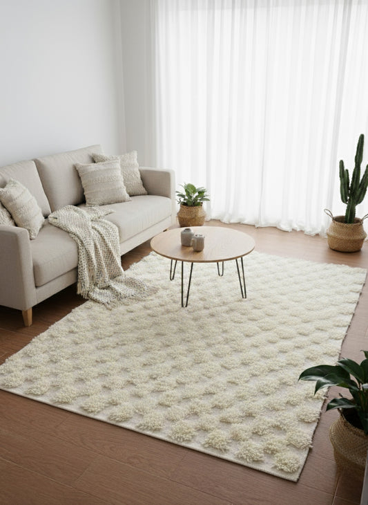 Neutral Moroccan wool rug in beige tones styled with armchair and lamp.
