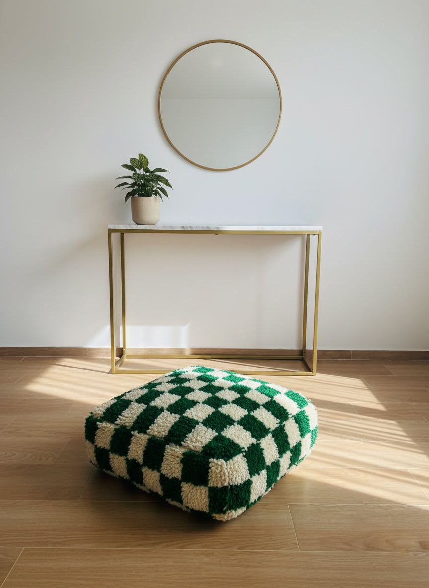 Green and cream Moroccan pouf placed in a minimal interior.