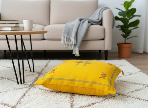 Handwoven Moroccan yellow floor pillow with Berber embroidery in cozy living space