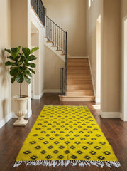 Yellow Berber Tilouin rug with black motifs styled in a bright hallway.
