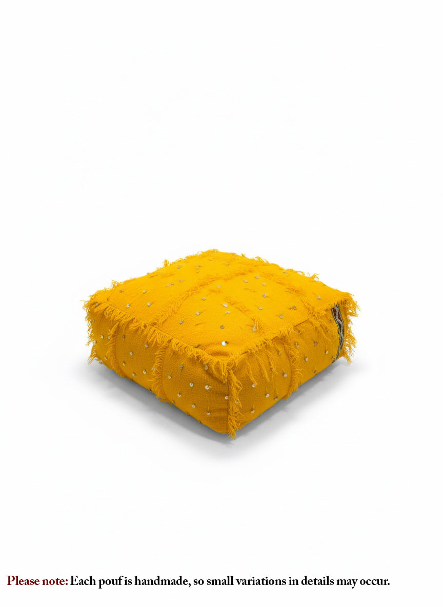 Handwoven yellow Moroccan pouf on white background showing textured details.