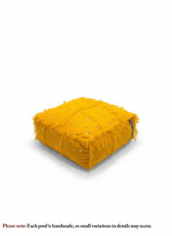 Handwoven yellow Moroccan pouf on white background showing textured details.